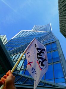 main brandissant le drapeau CFE-CGC devant le siège social de Thales