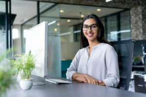 Femme souriante devant son ordinateur de travail